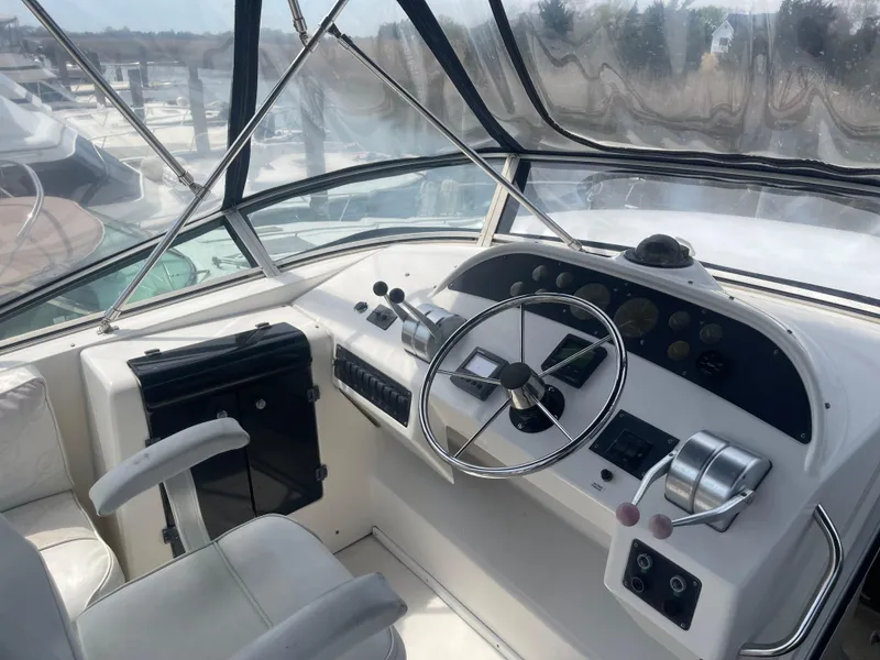 Slide: The Image of 1999 Bayliner 4788 Motoryacht helm with steering wheel and control panel. - 8