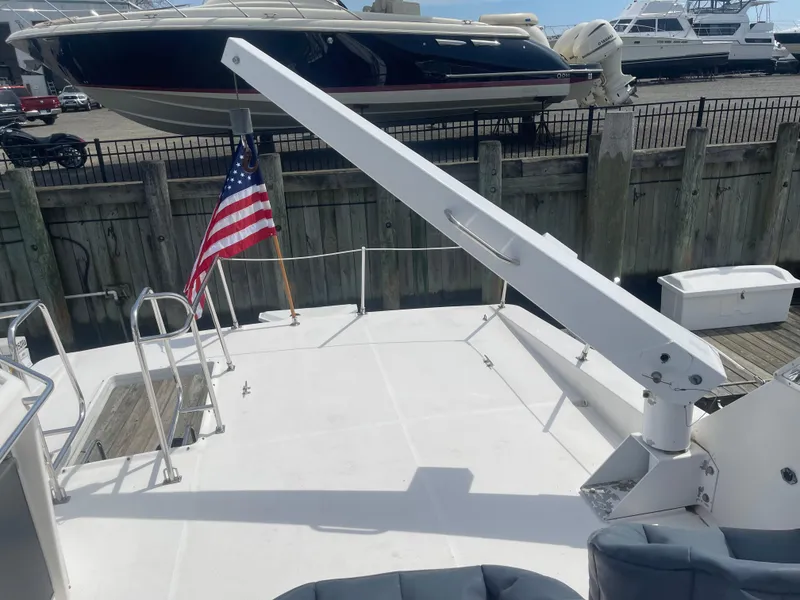 Slide: The Image of 1999 Bayliner 4788 Motoryacht deck with crane and American flag at marina. - 9