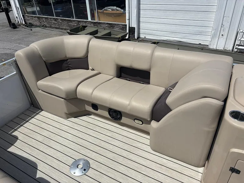 Slide: The Image of 2023 SunCatcher Fusion 22RC boat interior with beige seating on a wooden deck. - 13