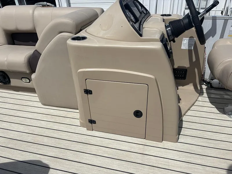 Slide: The Image of 2023 SunCatcher Fusion 22RC boat console with beige seating and steering wheel. - 16