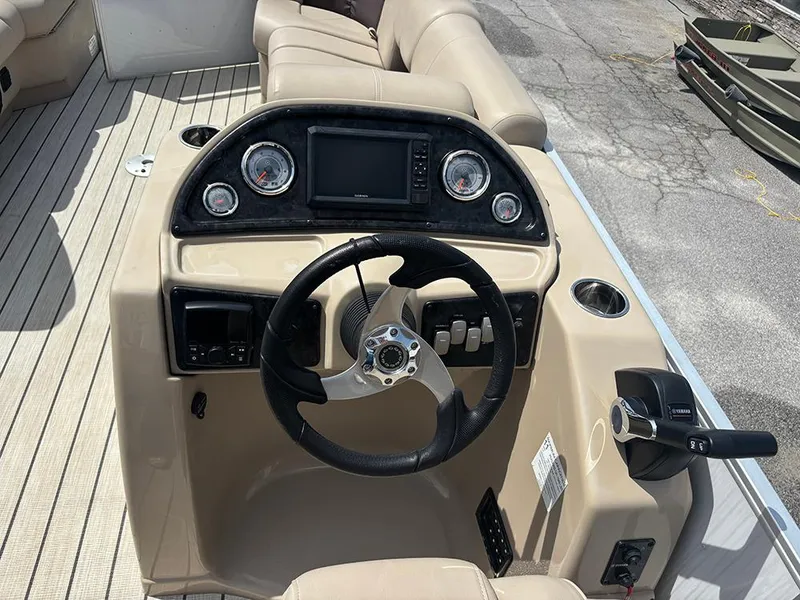 Slide: The Image of 2023 SunCatcher Fusion 22RC boat dashboard with steering wheel and controls. - 18