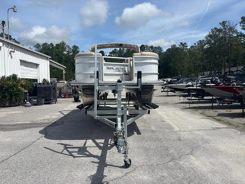 Slide: The Image of 2023 SunCatcher Fusion 22RC pontoon boat on trailer in outdoor storage area. - 2