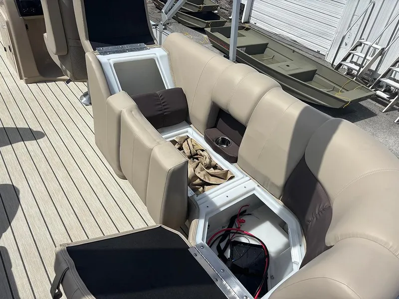 Slide: The Image of 2023 SunCatcher Fusion 22RC boat interior with open storage compartments and beige seating. - 20
