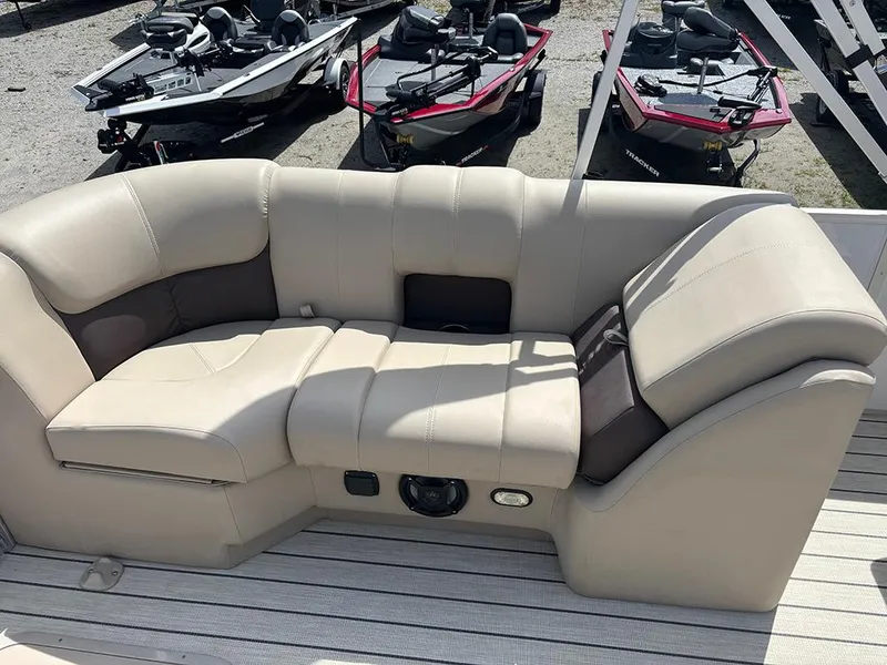 Slide: The Image of 2023 SunCatcher Fusion 22RC boat seating with beige upholstery, surrounded by parked boats. - 21