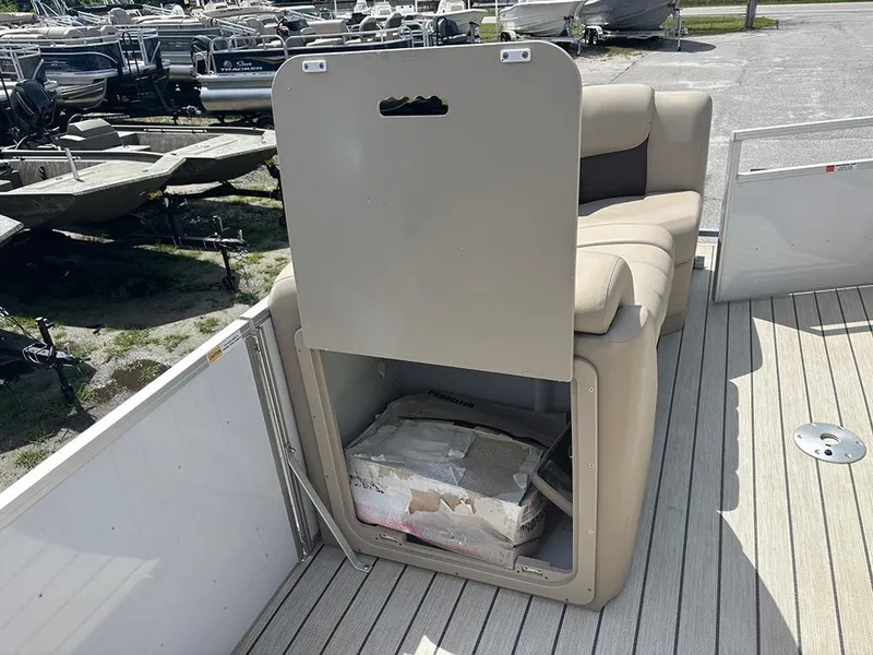 Slide: The Image of 2023 SunCatcher Fusion 22RC boat with open storage compartment under beige seating. - 24