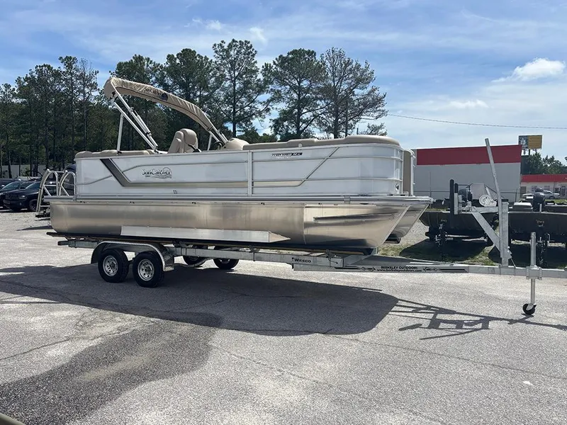 Slide: The Image of 2023 SunCatcher Fusion 22RC pontoon boat on a trailer, parked outdoors. - 3