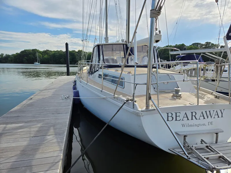Slide: The Image of Sailboat Amel Maramu 1985 docked, named "Bearaway," Wilmington, DE, on calm water. - 0