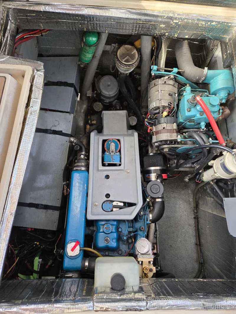 Slide: The Image of Engine compartment of a 1985 Amel Maramu sailboat, showcasing mechanical components and wiring. - 15