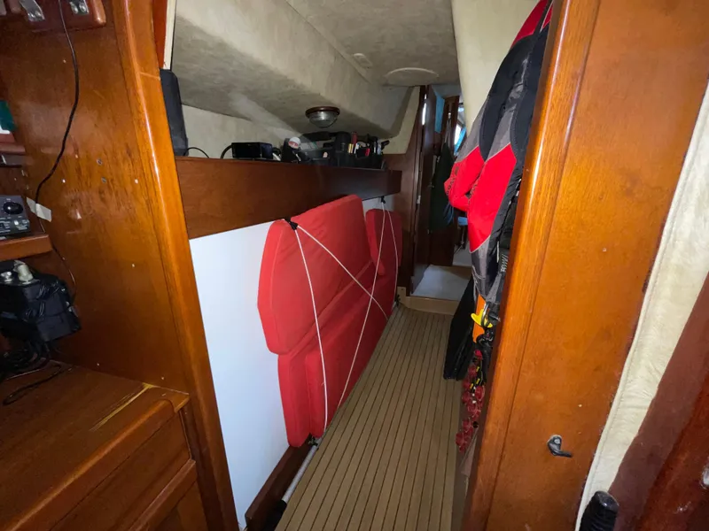Slide: The Image of Interior of 1985 Amel Maramu sailboat with wooden paneling and red cushions. - 20