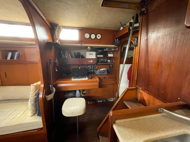 Slide: The Image of 1985 Amel Maramu yacht interior with navigation station and wooden furnishings. - 21