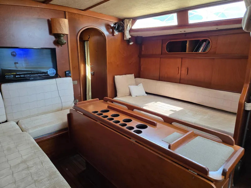 Slide: The Image of Interior of 1985 Amel Maramu sailboat with wooden furnishings and cozy seating area. - 27