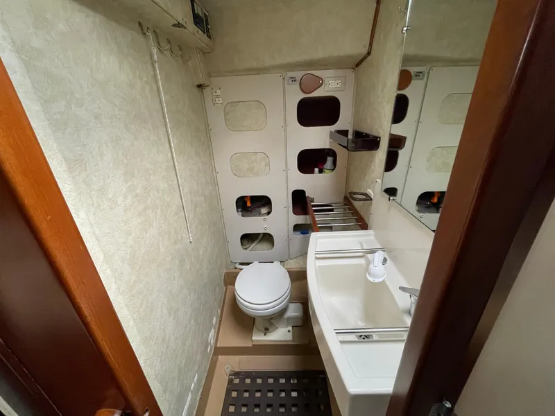 Slide: The Image of 1985 Amel Maramu yacht bathroom with toilet, sink, and storage compartments. - 33