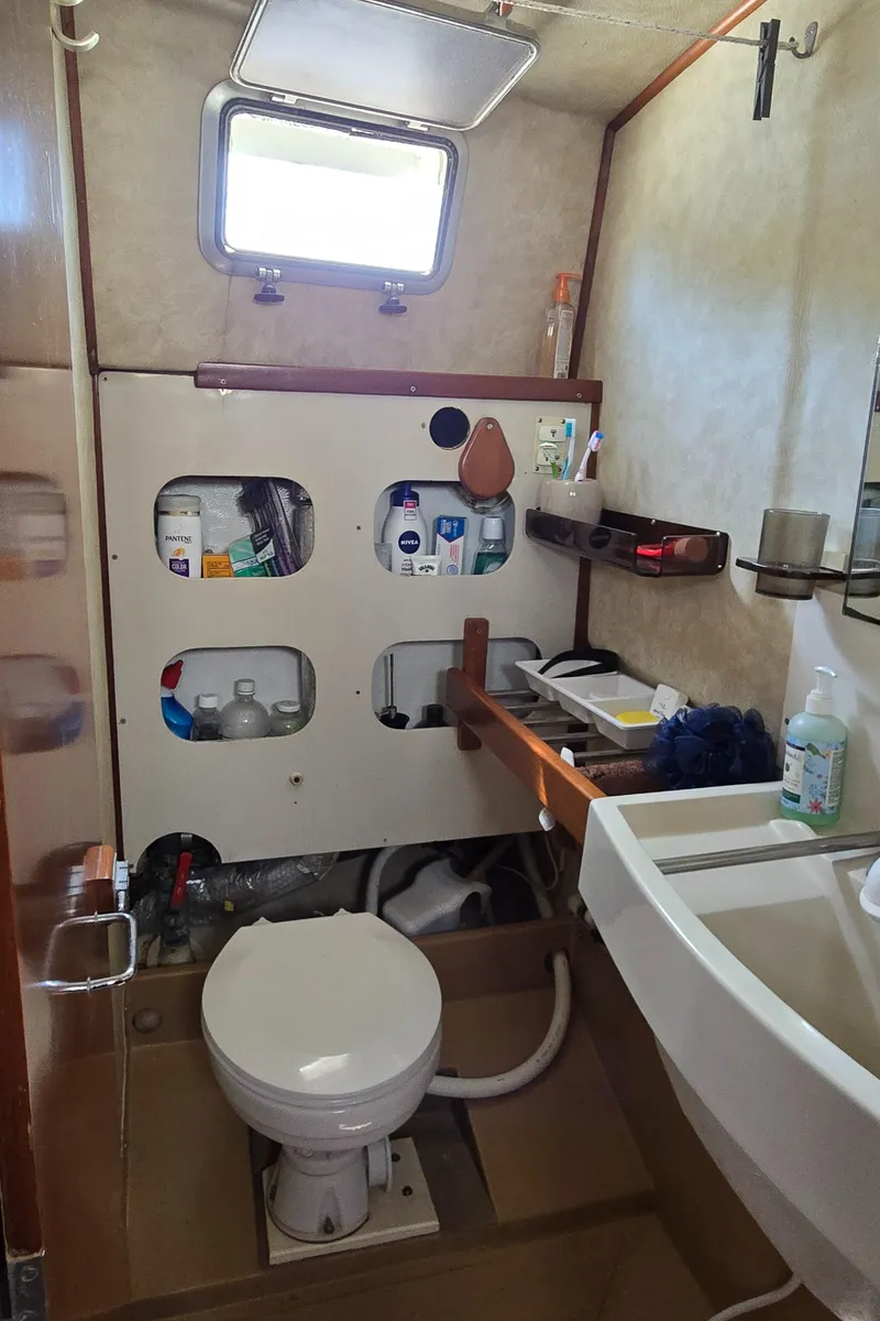 Slide: The Image of Bathroom interior of a 1985 Amel Maramu yacht, featuring storage shelves and a compact design. - 39