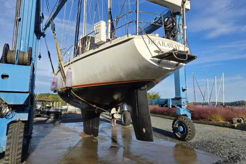 Slide: The Image of 1985 Amel Maramu sailboat on a lift for maintenance at a marina. - 52