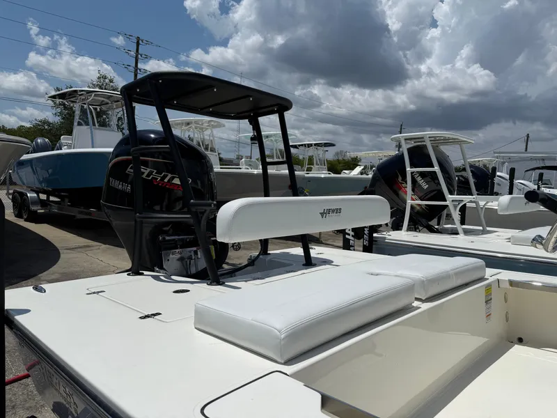 Slide: The Image of 2025 Hewes 18 Redfisher boat with white seating, parked outdoors under cloudy skies. - 6