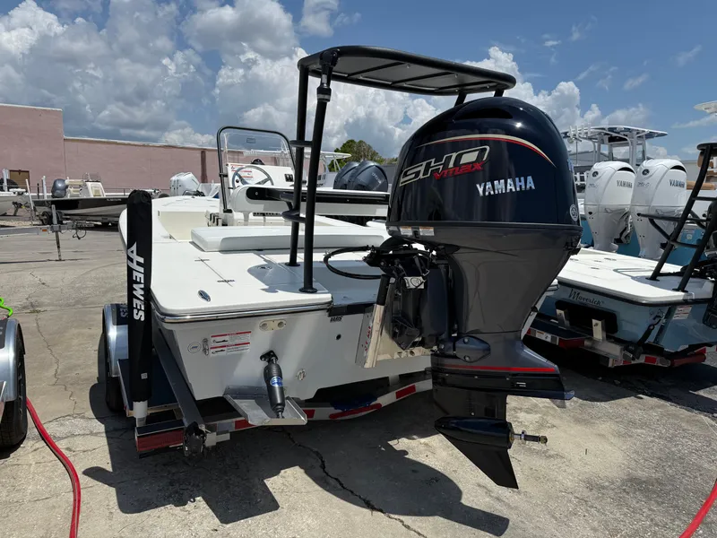 Slide: The Image of 2025 Hewes 18 Redfisher boat with Yamaha engine, parked outdoors. - 8
