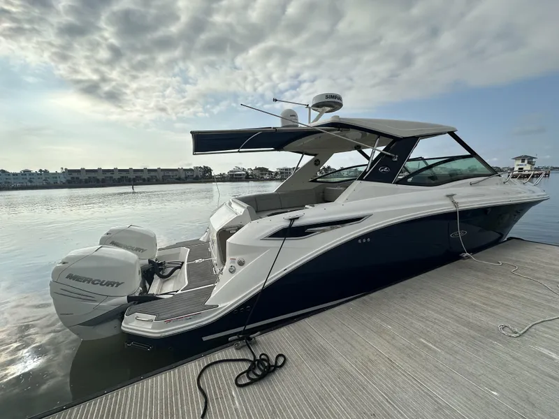 Slide: The Image of 2021 Sea Ray Sundancer 320 OB docked, featuring sleek design and twin Mercury outboard engines. - 1