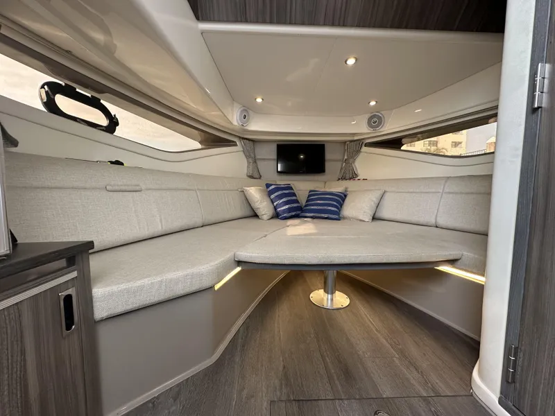 Slide: The Image of 2021 Sea Ray Sundancer 320 OB cabin interior with modern seating and ambient lighting. - 14