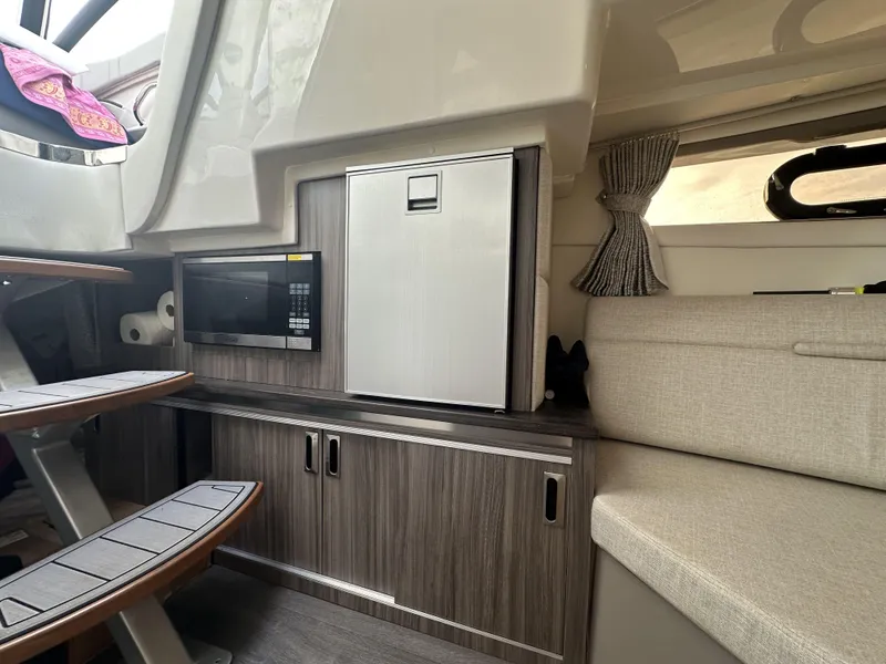 Slide: The Image of Interior of 2021 Sea Ray Sundancer 320 OB with kitchenette and seating area. - 15