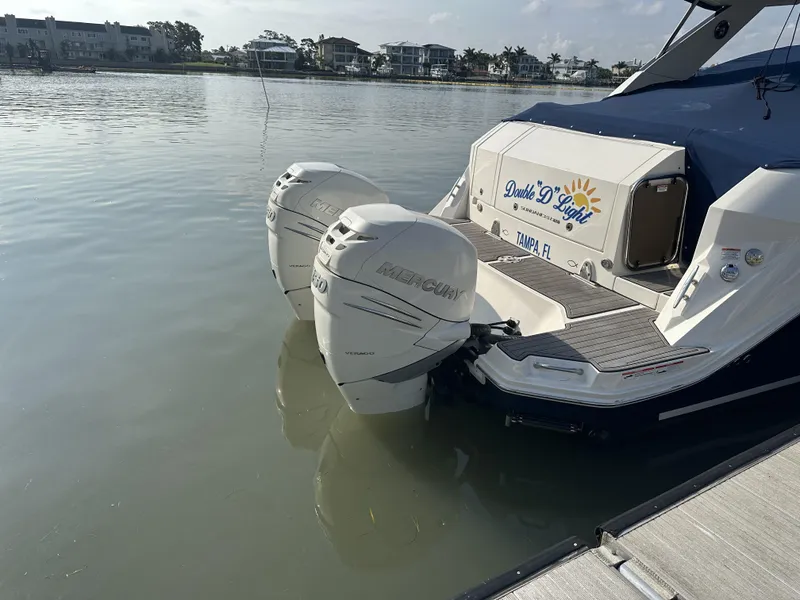Slide: The Image of 2021 Sea Ray Sundancer 320 OB with dual outboard motors docked by the water. - 17