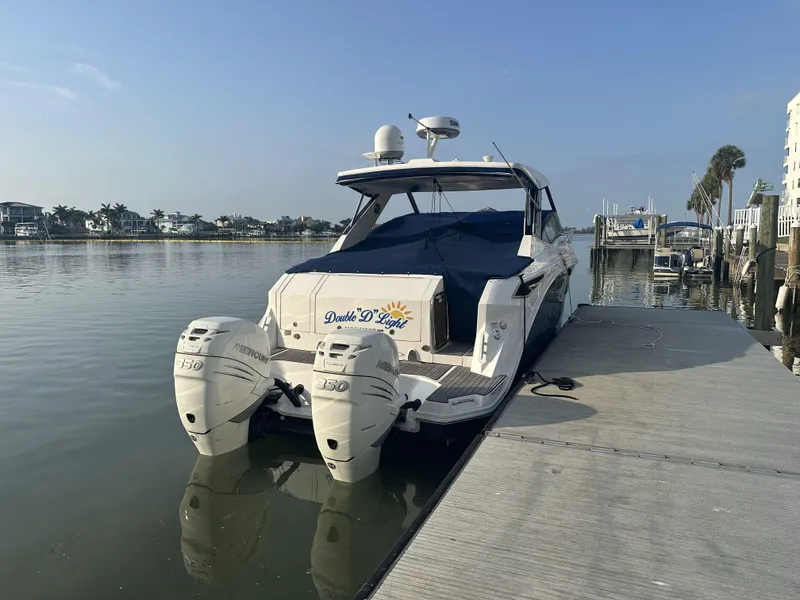 Slide: The Image of 2021 Sea Ray Sundancer 320 OB docked by calm waters, featuring twin outboard engines. - 18