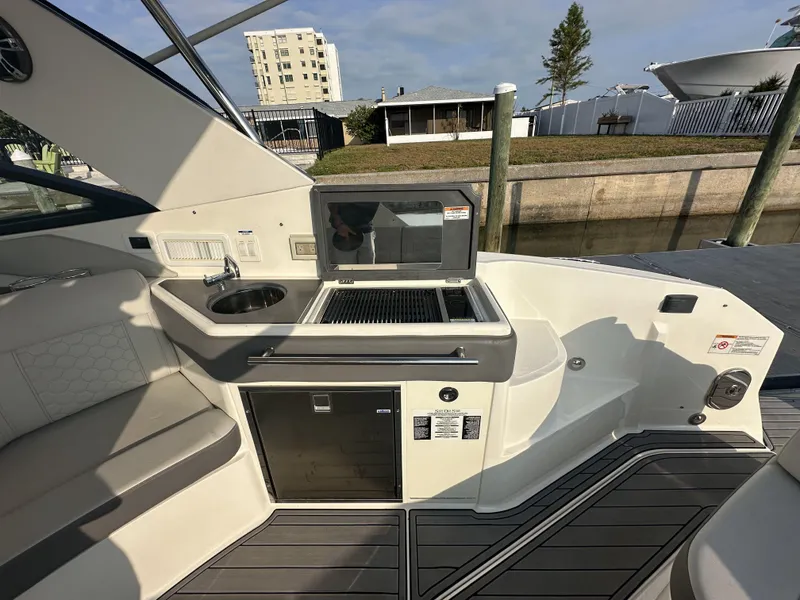 Slide: The Image of 2021 Sea Ray Sundancer 320 OB boat interior with kitchenette and seating area. - 5