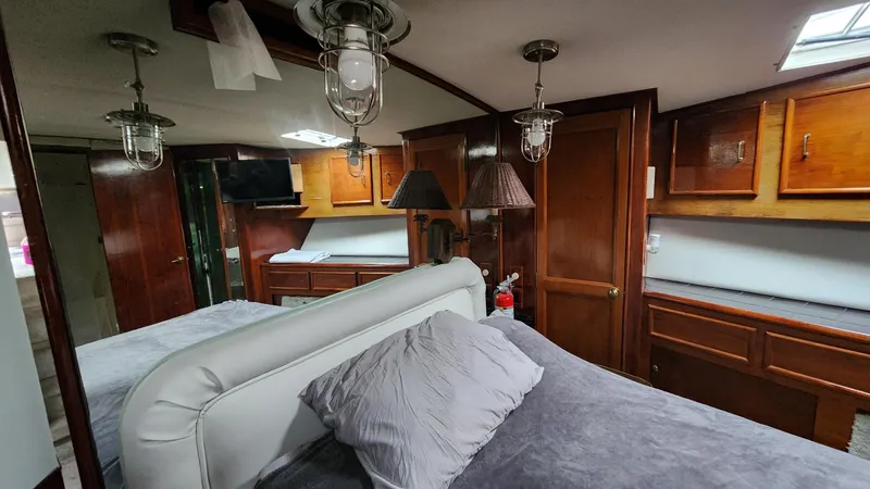 Slide: The Image of Luxurious interior of a 1989 Ocean Yachts 55, featuring elegant wood cabinetry and cozy bedding. - 11