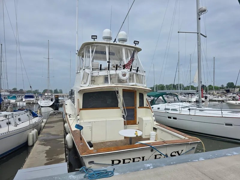 Slide: The Image of 1989 Ocean Yachts 55 docked at marina, surrounded by sailboats under cloudy sky. - 15