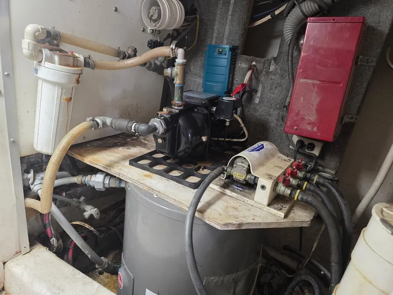 Slide: The Image of Engine room of a 1989 Ocean Yachts 55, featuring mechanical components and hoses. - 18