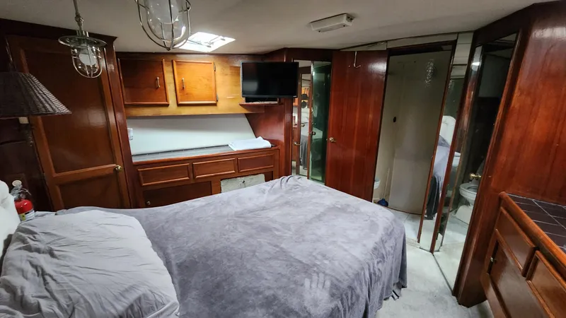 Slide: The Image of Luxurious cabin interior of a 1989 Ocean Yachts 55, featuring wood paneling and a cozy bed. - 10