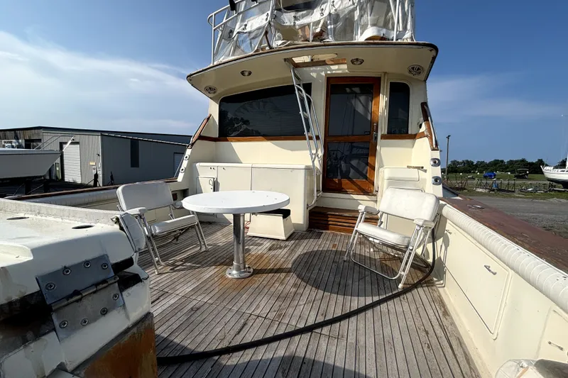 Slide: The Image of 1989 Ocean Yachts 55 Super Sport deck with chairs and table under clear sky. - 25