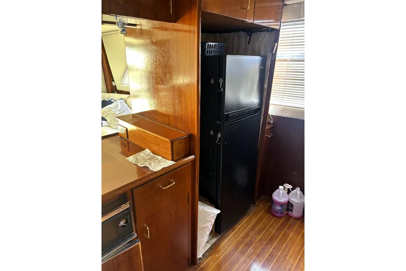 Slide: The Image of 1989 Ocean Yachts 55 Super Sport interior with wooden cabinetry and black refrigerator. - 20