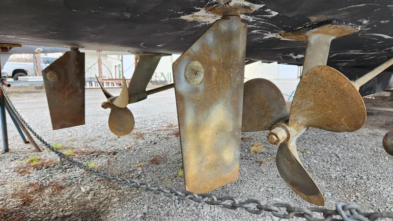 Slide: The Image of Underside view of 1989 Ocean Yachts 55 showing propellers and rudders on gravel. - 16