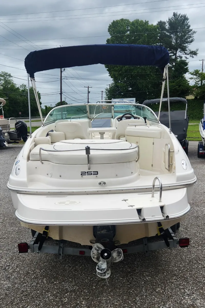 Slide: The Image of 2003 Monterey 253 Explorer Sport boat with canopy, parked on gravel. - 3