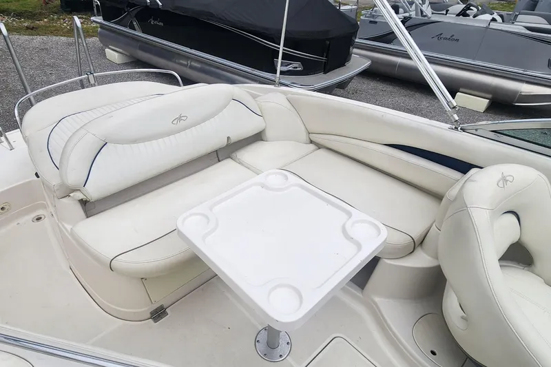 Slide: The Image of 2003 Monterey 253 Explorer Sport boat interior with white seating and table. - 5