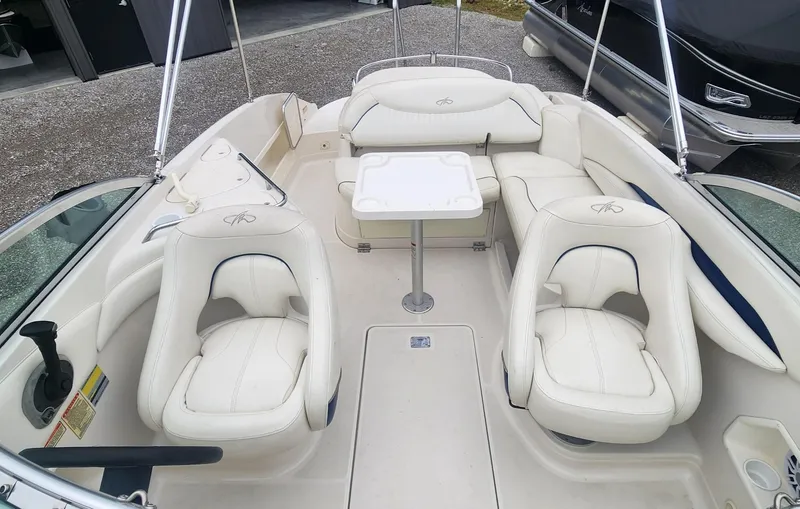 Slide: The Image of 2003 Monterey 253 Explorer Sport boat interior with white seating and table. - 6