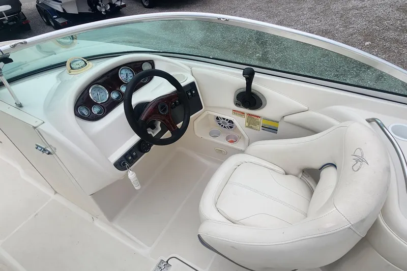 Slide: The Image of 2003 Monterey 253 Explorer Sport boat cockpit with steering wheel and white seating. - 7