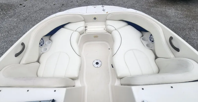 Slide: The Image of 2003 Monterey 253 Explorer Sport boat interior with white seating and cup holders. - 8