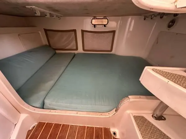 Slide: The Image of 2005 Grady-White Marlin 300 cabin interior with blue cushions and wooden flooring. - 8