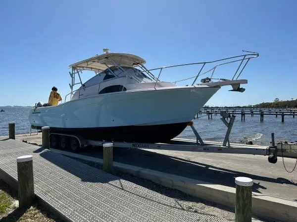 Slide: The Image of 2005 Grady-White Marlin 300 boat on trailer by the water, sunny day. - 2