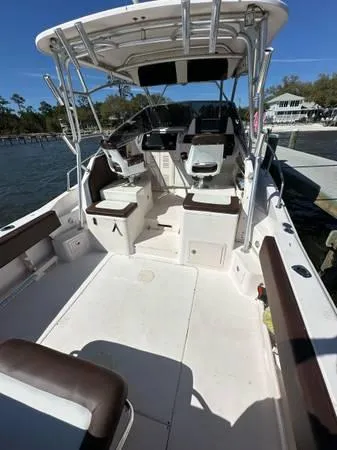 Slide: The Image of 2005 Grady-White Marlin 300 boat interior with seating and helm, docked by the water. - 6