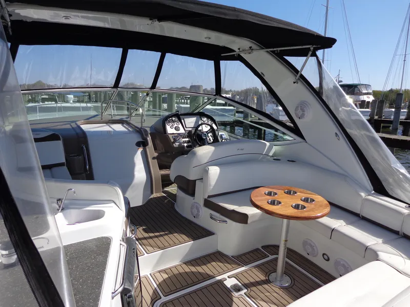 Slide: The Image of 2008 Cruisers Yachts 330 Express interior with seating and helm, docked at marina. - 2