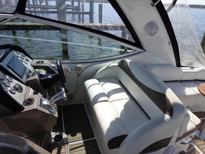 Slide: The Image of 2008 Cruisers Yachts 330 Express cockpit with steering wheel and seating, overlooking water. - 7
