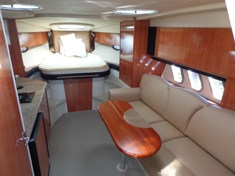 Slide: The Image of 2008 Cruisers Yachts 330 Express interior with bed, sofa, and kitchenette. - 12