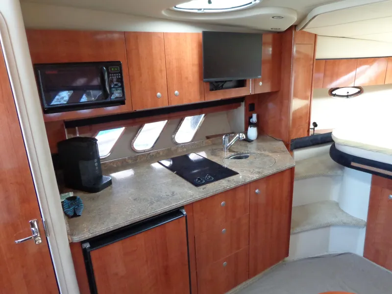 Slide: The Image of 2008 Cruisers Yachts 330 Express interior kitchen with wood cabinets and modern appliances. - 14
