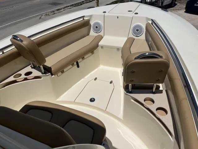 Slide: The Image of 2018 Scout 255 LXF boat interior with tan seating and cup holders. - 3