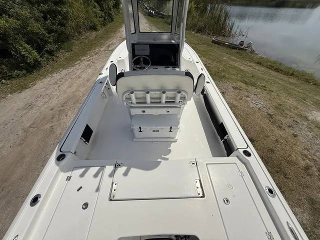 Slide: The Image of 2024 Tidewater 2410 Bay Max boat, spacious deck, white interior, near a lake. - 12