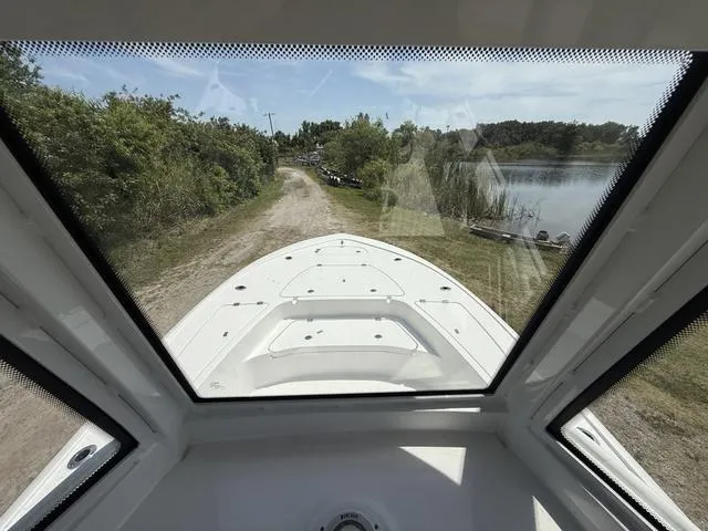 Slide: The Image of 2024 Tidewater 2410 Bay Max boat on a scenic lakeside path. - 16