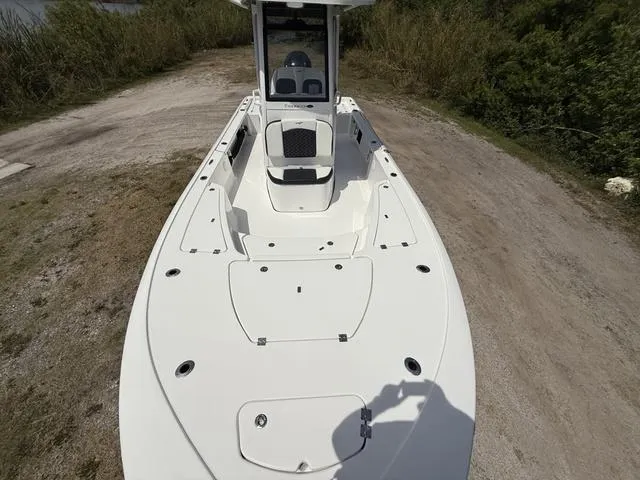 Slide: The Image of 2024 Tidewater 2410 Bay Max boat on a dirt path, surrounded by greenery. - 18