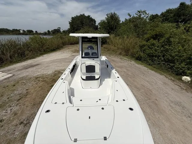 Slide: The Image of 2024 Tidewater 2410 Bay Max boat on a dirt path near lush greenery. - 19